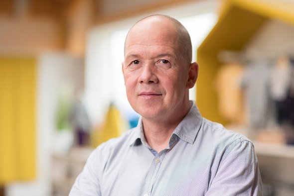 Porträt des disana CEO Elmar Sautter im hellen Hemd, lächelnd im disana Laden in Holzelfingen