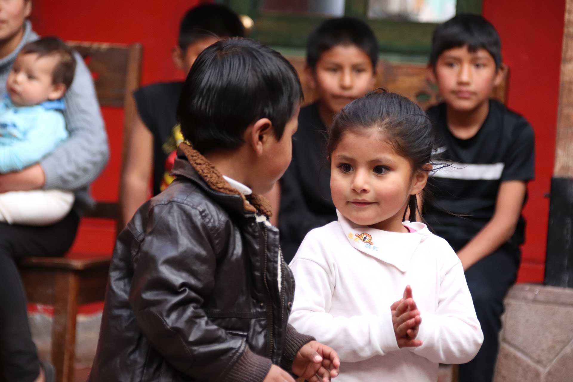 Casa Mantay, Cusco, Peru: Junge in Lederjacke & Mädchen in hellem Oberteil stehen sich gegenüber & schauen sich an